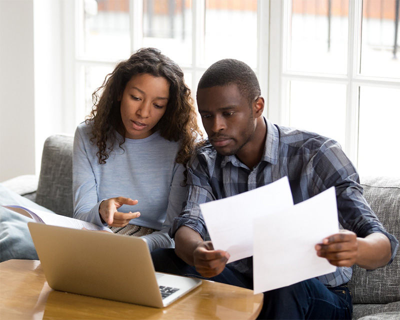 Man and woman conversing in front of a laptop