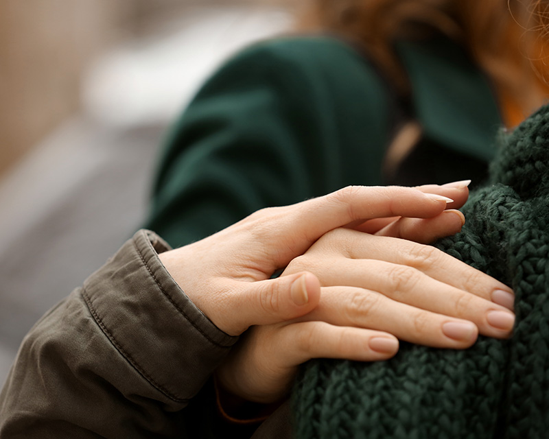 Woman's hand on another person's shoulder