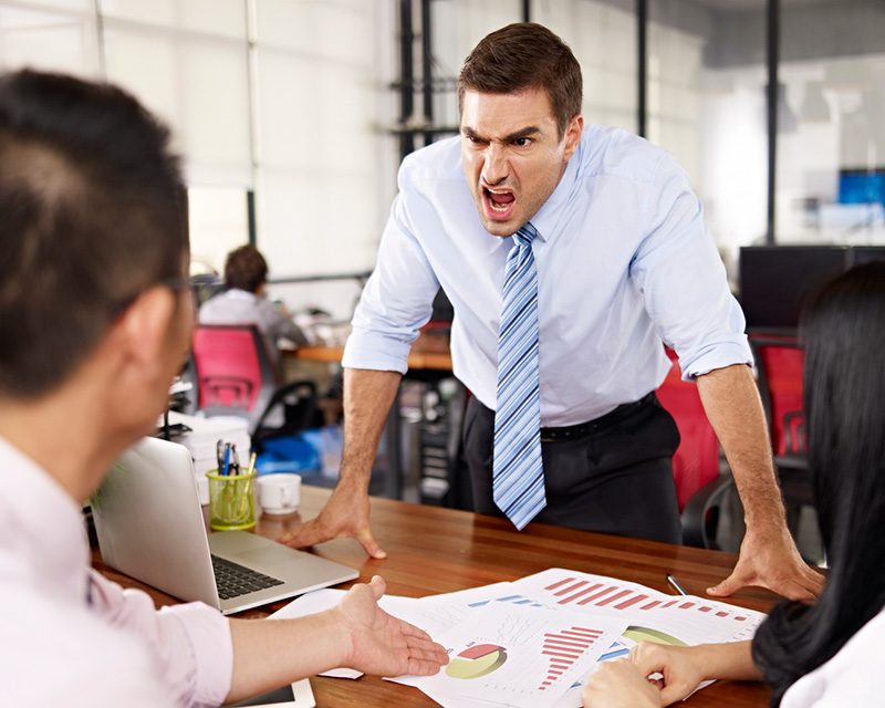 Man yelling at coworker over desk